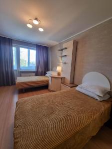 - une chambre avec 2 lits et une fenêtre dans l'établissement Naftininkų g. 8, à Mažeikiai