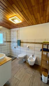 ein großes Badezimmer mit zwei Waschbecken und zwei WCs in der Unterkunft Franky House am Nürburgring in Quiddelbach