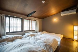 a room with two beds in it with windows at 京·馨 in Kyoto