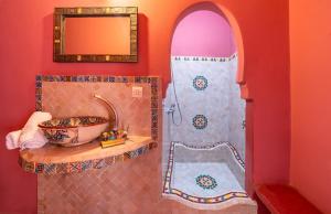 a bathroom with a shower with a sink and a bowl at Riad Todra in Marrakesh