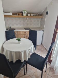 a kitchen with a table and two blue chairs and a table and chairsktop at Old town - AP3 in Tribunj