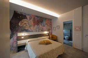 a bedroom with a bed with a painting on the wall at Hotel Campanello in Castelnuovo del Garda