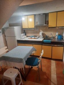 a small kitchen with a table and a refrigerator at Apartments Stars in Ohrid