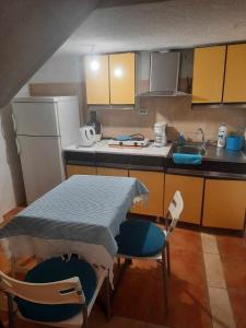 cocina con mesa, sillas y nevera en Apartments Stars, en Ohrid
