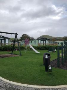 Lakeland Retreat في Lamplugh: حديقة مع ملعب مع زحليقة
