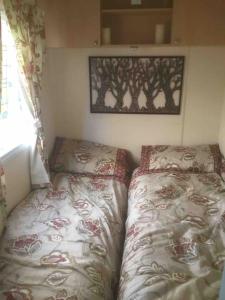 Lakeland Retreat في Lamplugh: غرفة نوم صغيرة بسريرين وصورة على الحائط