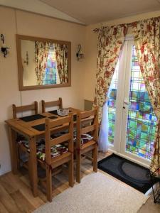 a dining room with a table and chairs and a window at Lakeland Retreat in Lamplugh