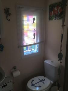 a bathroom with a white toilet and a window at Lakeland Retreat in Lamplugh