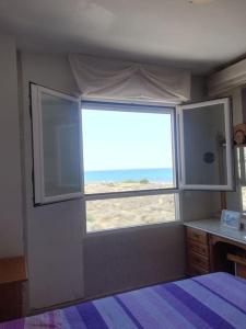um quarto com uma janela com vista para a praia em Apartamento playa Muchavista em El Campello