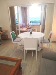 ein Wohnzimmer mit einem weißen Tisch und Stühlen in der Unterkunft Apartamento playa Muchavista in El Campello