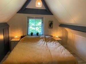 a bedroom with a large bed and a window at Bosboerderij de Goudsberg met hottub in tuin in Lunteren +25 photos