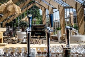 una mesa con copas de vino en una habitación con ventanas en KASerne Boutique Hotel en Den Bosch