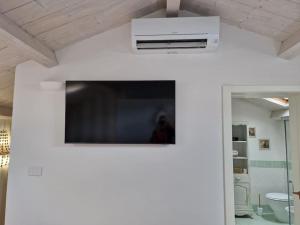 pared blanca con TV en la pared en Appartamento Shabby 123, en Grosseto