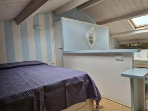 1 dormitorio con cama morada y mesa en Appartamento Shabby 123, en Grosseto