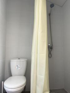 a bathroom with a toilet and a shower curtain at PitStop Motel in Kamianske