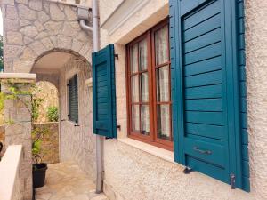 una casa con persianas azules y una puerta en Villa Chantal, en Kotor