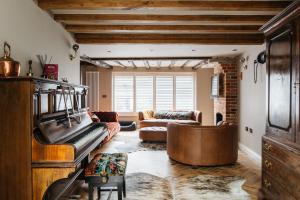 uma sala de estar com um sofá e um piano em Crippens, A historic 5 star Home Hotel Free Parking EV, inglenook fireplace em Canterbury