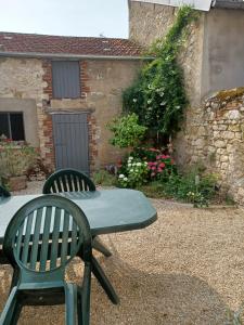 zielony stół i krzesła przed budynkiem w obiekcie Entre Loire et canal w mieście Briare
