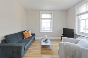 een woonkamer met een bank en een tv bij Fabulous three bedroom flat near Marylebone by UnderTheDoormat in Londen