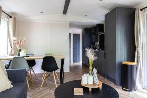 a living room with a couch and a table at Prachtig chalet in de bossen in Nunspeet