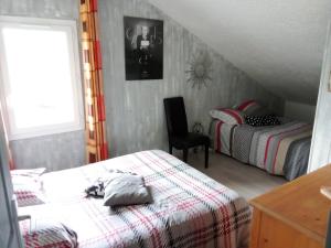 1 dormitorio pequeño con 2 camas y 1 silla en Chalet familial à la montagne en Caille