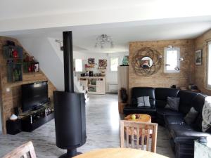 Chalet familial à la montagne في Caille: غرفة معيشة مع أريكة سوداء ومدفأة