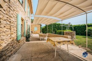 un patio con mesa y sombrilla en Petit Mas au calme proche centre, en Bagnols-sur-Cèze