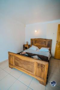 1 dormitorio con 1 cama grande de madera en una habitación en Petit Mas au calme proche centre, en Bagnols-sur-Cèze