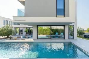 een huis met een zwembad ervoor bij Villa Marli ZadarVillas in Zaton