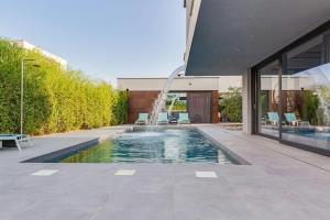 een zwembad met een fontein voor een gebouw bij Villa Marli ZadarVillas in Zaton