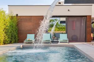 een fontein voor een gebouw met twee ligstoelen bij Villa Marli ZadarVillas in Zaton