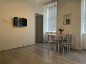 a dining room with a table and chairs and a television at Villa History in Crikvenica