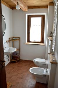 マッサ・マルターナにあるAgriturismo La Collinaのバスルーム(トイレ2つ、洗面台、窓付)