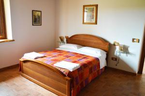 マッサ・マルターナにあるAgriturismo La Collinaのベッドルーム1室(木製ベッド1台、タオル2枚付)