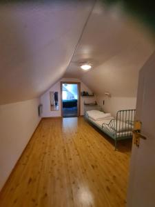 an attic room with a bed and a wooden floor at Hjälmarödsgård in Kivik