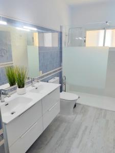 ein weißes Bad mit einem Waschbecken und einem WC in der Unterkunft Coastal Dream with heated pool in El Escobonal