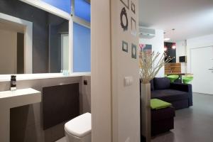 a bathroom with a toilet and a sink and a couch at City Center Apartment in Barcelona