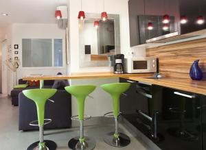 une cuisine avec des tabourets de bar verts et un comptoir dans l'établissement City Center Apartment, à Barcelone