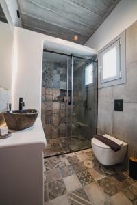 uma casa de banho com um chuveiro, um WC e um lavatório. em Falakis Apartments em Kythnos