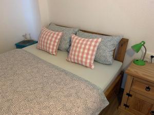 Una cama con cuatro almohadas encima. en Am Sonnenhang, en Hilzingen