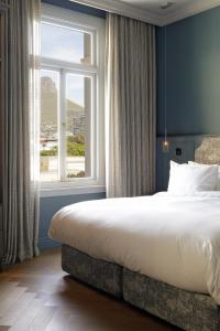 a bedroom with a large bed and a large window at Labotessa Luxury Boutique Hotel in Cape Town