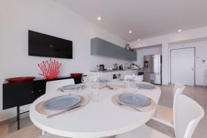 Neve Tzedek Apartment-Hosted by Sweetstay في تل أبيب: غرفة طعام بيضاء مع طاولة بيضاء وكراسي