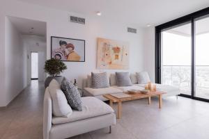 Neve Tzedek Apartment-Hosted by Sweetstay في تل أبيب: غرفة معيشة مع أريكة وطاولة