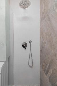 La salle de bains est pourvue d'une douche avec un pommeau de douche. dans l'établissement Marina Luxury Apartments Durrës, à Durrës