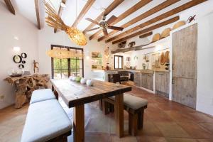 a large kitchen with a wooden table and chairs at CA'N LA in Deia