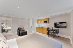 a room with a bed and a table and a kitchen at Cleveland Residences Paddington in London