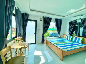 Hotel Cù Lao 3 في Tây Ninh: غرفة نوم بسرير وطاولة وكراسي