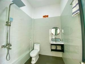 a white bathroom with a toilet and a mirror at Hotel Cù Lao 3 in Tây Ninh