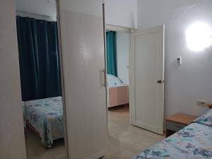 a small bedroom with two beds and a mirror at Appartement Fethia in Houmt Souk