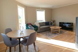 a living room with a table and a couch at Cozy and new apartment in Arendal -Hill in Arendal